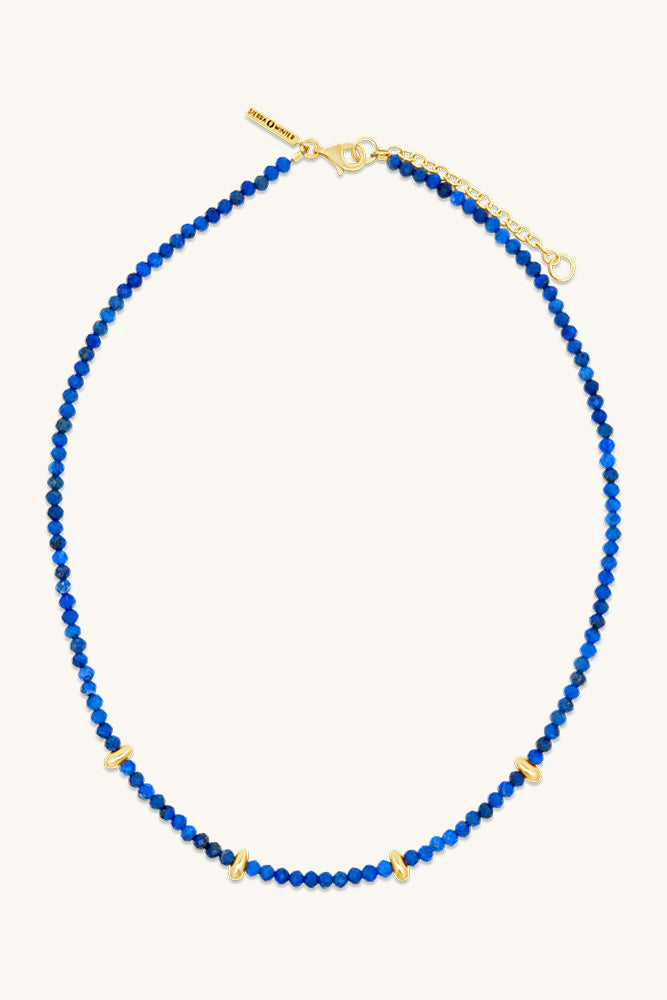 Blue beaded necklace with gold clasp on a white background