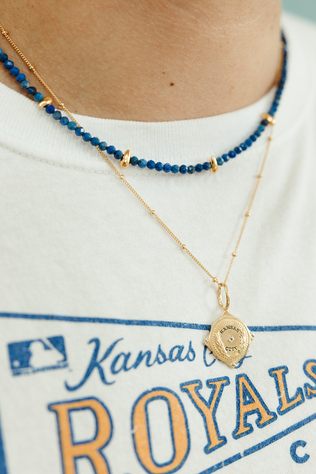 faceted lapis small beaded necklace with gold accents layered with kansas city pendant on chain