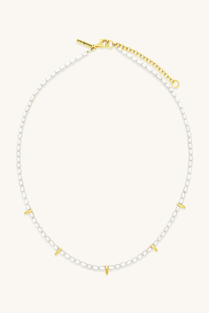 Necklace with white pearls and gold accents on a white background