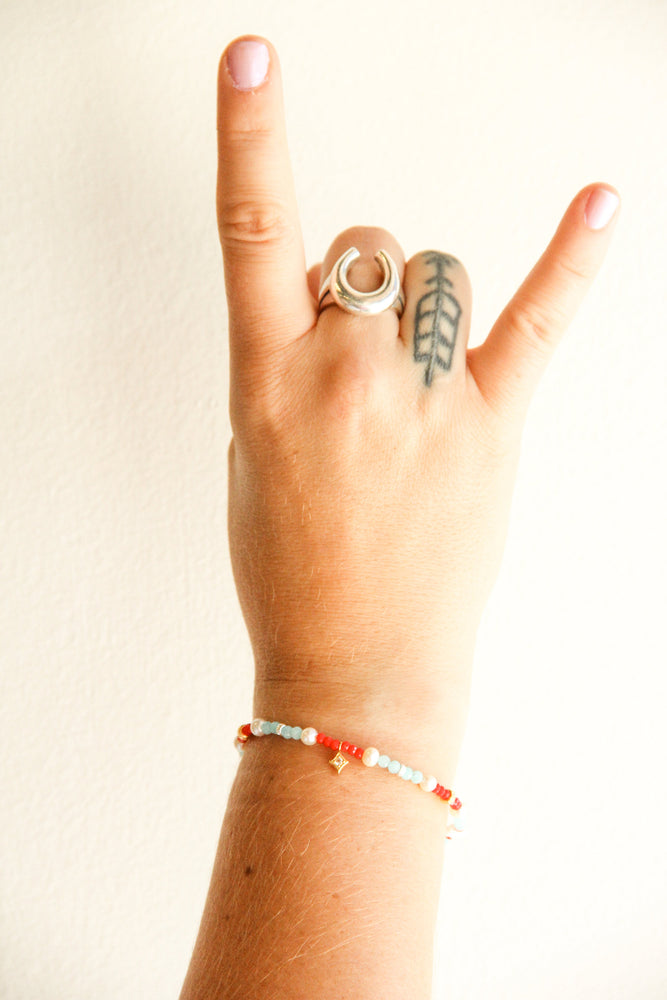 
                      
                        handmade beaded teal and red bracelet with gold and pearl accents
                      
                    