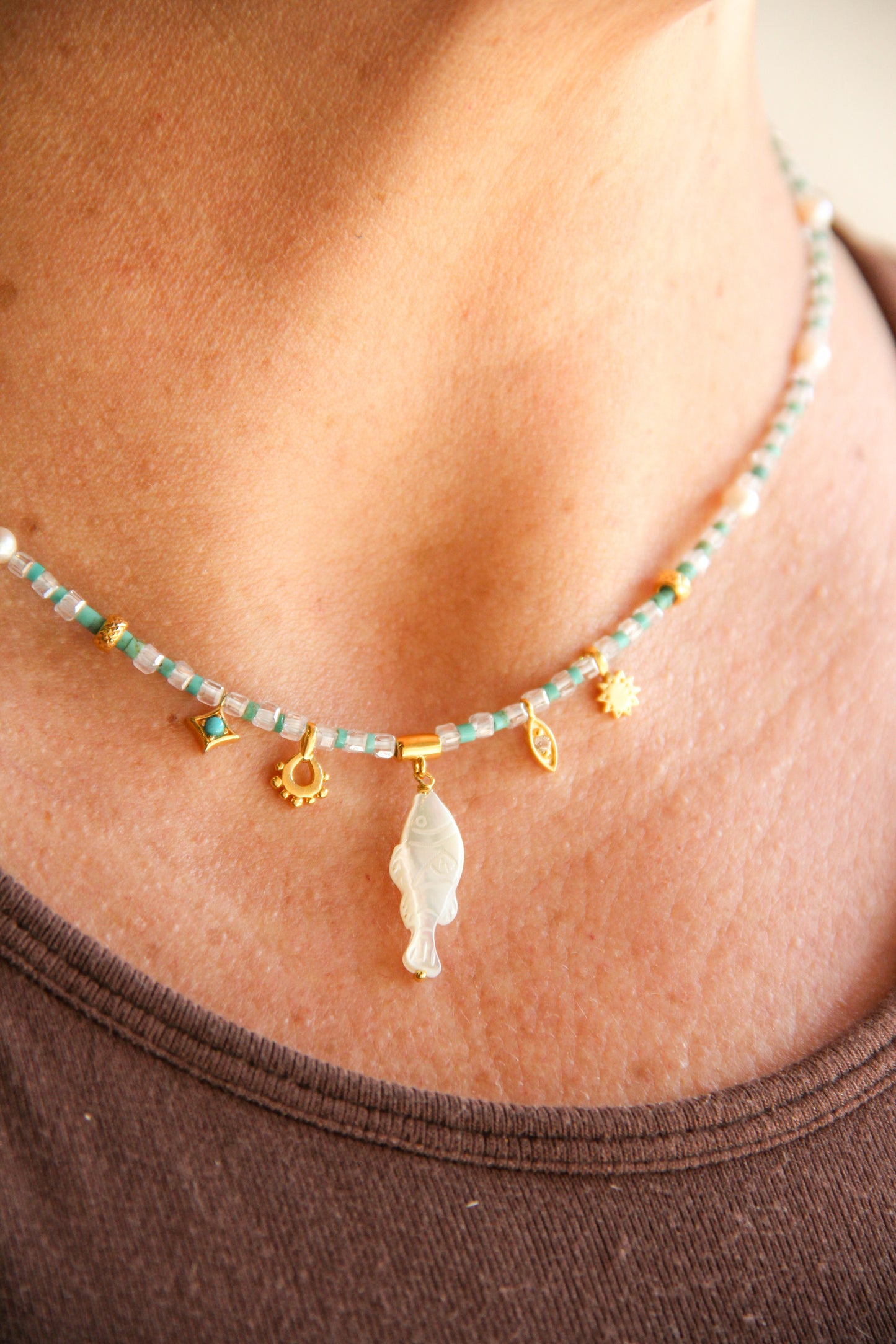 white topaz and turqoise beaded necklace with a carved mother of pearl fish charm