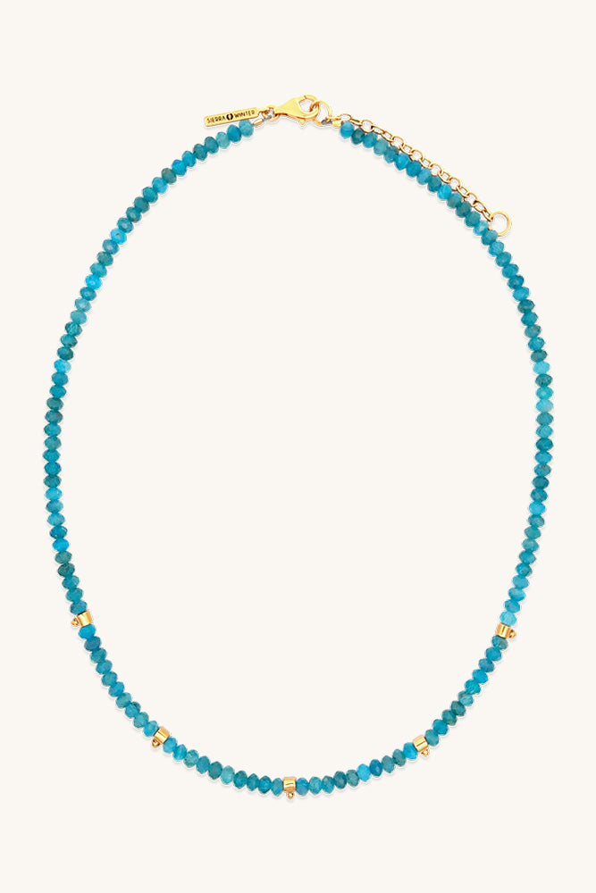 Blue beaded necklace with gold clasp on a white background