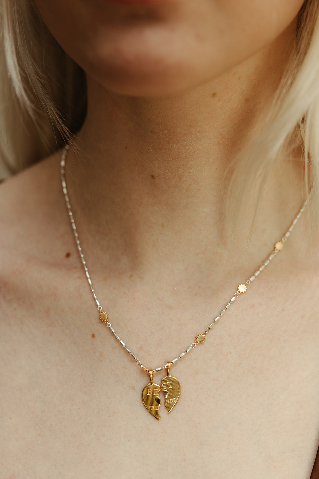 Gold necklace with heart-shaped pendants on a person's neck