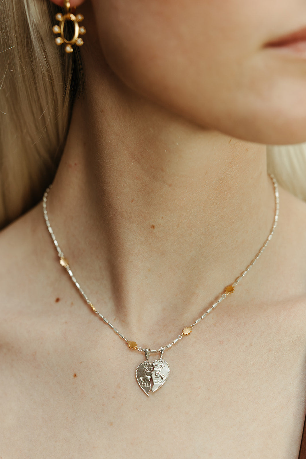 Necklace with silver heart-shaped pendants worn by a person